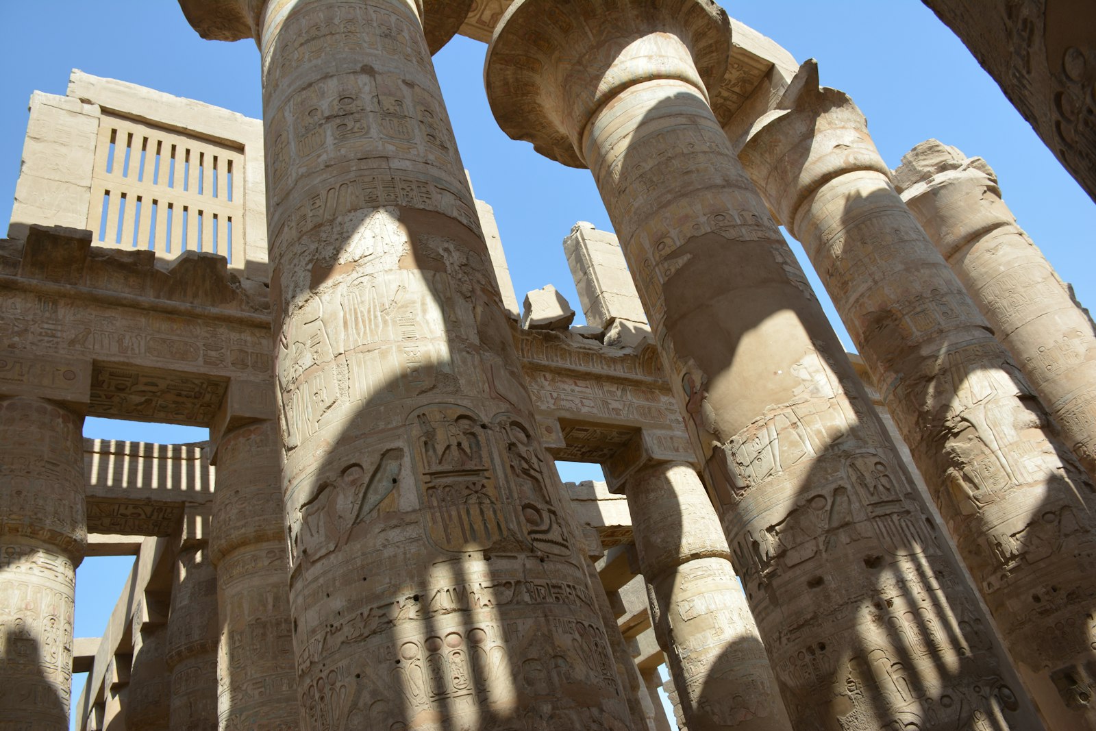 Tall carved stone columns of the Great Hypostyle Hall at Karnak temple under a blue sky